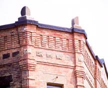 Detail view of the Apothecaries Hall emphasizing its banded brick facing with decorative brick cornice, 1995.; Parks Canada Agency / Agence Parcs Canada, J. Butterill, 1995.