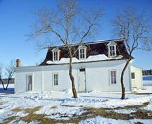 Front facade of the Officers' Quarters, showing the simple, two-storey massing of the building, 1991.; Agence Parcs Canada / Parks Canada Agency, D. McArthur, 1991.