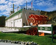 Vue générale de l'arrière du S.S. Keno montrant les  roues à aubes qui garantient l'intégrité physique du navire attestée par sa masse initiale, la conception et la construction de sa coque, 2002.; Parks Canada Agency / Agence Parcs Canada, J. Armitage, 2002.