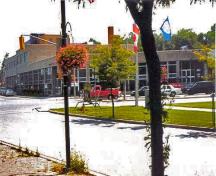 Vue générale de l'édifice du gouvernement du Canada mettant de l'emphase sur la visibilité du bâtiment, en raison de son échelle imposante et de son emplacement bien en vue sur une grande artère commerciale qui débouche dans le centre-ville de Belleville.; Parks Canada Agency / Agence Parcs Canada, n.d.