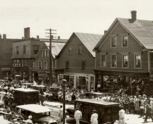 884-886 1/2 Main St. as seen from the Subway crossing during a funeral procession for victims of the Barnes Circus train wreck in 1930.; Moncton Museum