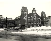 Vue générale de la façade principale du manège militaire de la place Cartier, 1984.; Monique Trépanier, Parks Canada Agency / Agence Parcs Canada, 1984.