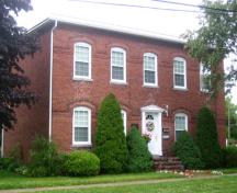 Image of the brick tenement building, side angle, showing regularly spaced windows and balanced front façade.; City of Fredericton