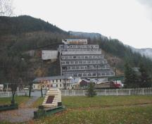 General view of Britannia Mines Concentrator showing its geographic location, at the edge of the mountains, close to an ocean harbour, 2002.; Parks Canada Agency / Agence Parcs Canada, 2002.