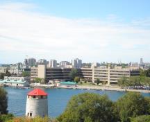 View of the former Kingston Navy Yard, showing Navy Bay and the 3-storey stone frigate at right, 2008.; Parks Canada Agency / Agence Parcs Canada, 2008.