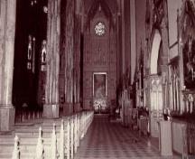 View of an aisle of St. Patrick's Basilica, showing the tall imposing sanctuary, 1996.; Parks Canada Agency / Agence Parcs Canada, S. Ricketts, 1996.