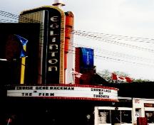 Close view of Eglinton Theatre showing the sign tower and semi-circular marquee; Agence Parcs Canada \ Parks Canada Agency, J. Mattie, 1993.