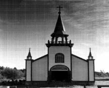 General view of St. Peter’s Anglican Church, showing the rectangular massing with a gable-ended, pitched roof and a porch of smaller but similar form surmounted by a belfry.; Hay River Dene Band / Bande des Dénés de Hay River.