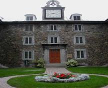 Detailed view of Saint-Sulpice Seminary, showing the main door and the clock with mounted bells.; Parks Canada Agency / Agence Parcs Canada.