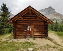 Front facade of the Halfway Hut showing the deep overhang above the cabin entrance.; Parks Canada Agency / Agence Parcs Canada, n.d.