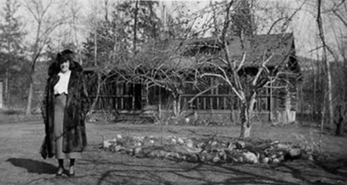 Historic exterior view of Bertie Beaton in front of the house, c.1930