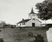 View of the Little Dutch (Deutsch) Church, showing its collection of early grave markers, haphazardly set within the uneven, sloping ground, 1965.; Parks Canada Agency / Agence Parcs Canada, 1965.