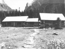 General view of the Elizabeth Parker Hut (left) and Wiwaxy Lodge (right)showing the simple massing of the rectangular building and pitched roof with a generous overhang, 1987.; Public Works Canada / Ministère des Travaux publics, A. Powter, 1987