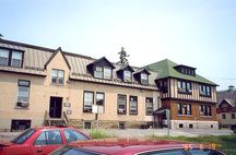 View of the side of the Horticulture Building, showing the stucco walls and irregularly spaced windows and dormers, 1995.; Department of Agriculture / Ministère de l'Agriculture, Patricia Armstrong, 1995.