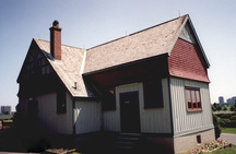 View of the entrance of the Potting Shed, showing the vertical board-and-batten siding and half-timbering on the gable ends, 1995.; Parks Canada Agency / Agence Parcs Canada, 1995.