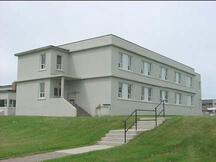 Vue arrière du côté de l'aile du Bâtiment de caserne (bâtiment H23) à la base des Forces canadiennes Gagetown.; Department of National Defence / Ministère de la Défense nationale, 2001.