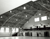 Vue de l'intérieur du manège militaire, qui montre le grand volume dégagé de la salle d’exercices avec ses fermes en acier apparentes, 1988.; Parks Canada Agency / Agence Parcs Canada, J. Hucker, 1988.