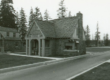 Side view of Building 2, showing the cedar shingles laid in staggered lines, the half-timbering of the upper portion of the building and the use of locally quarried split fieldstone in irregular courses for the exterior walls, 1985.; Parks Canada Agency / Agence Parcs Canada, 1985.