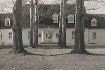 General view of Governors' Cottage, showing its formal, pillared, classically inspired entry porch, 1973.; Agence Parcs Canada / Parks Canada Agency, 1973.