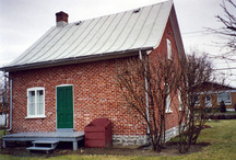 Vue de l'extérieur de la maison Wilfrid Laurier, qui montre le mur arrière partiellement aveugle qui évoque les anciennes dépendances de ferme qui ont été démolies lorsque la maison a été déménagée, 1992.; Parks Canada Agency / Agence Parcs Canada, 1992.