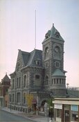 General view of the Former Galt Post Office, showing the imposing side tower with a clock and pyramidal roof.; Parks Canada | Parcs Canada, 1989