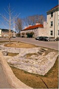 General view of Fort Frontenac, showing sections of the north curtain wall and the west curtain wall in a traffic circle at the intersection of Ontario Street and Place D’Armes, 1995.; Parks Canada Agency / Agence Parcs Canada, J. Butterill, 1995.