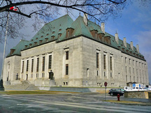 Vue en angle de l'Édifice de la Cour suprême mettant de l'emphase sur l’aménagement paysager, qui garde des vestiges des plans paysagers d’esprit Beaux-Arts, 2011.; Parks Canada | Parcs Canada, M. Therrien, 2011.