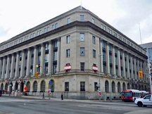 General view of the Wellington Building showing the strong base storey with round-headed openings, a grand three-storey centre portion marked by Corinthian colonnades and pilasters, and a substantial cornice and parapet, 2011.; Parks Canada | Parcs Canada, M. Therrien, 2011.