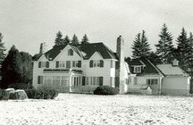 View of the Prime Minister's Cottage, showing its stone fireplaces and open verandah, 1985.; Parcs Canada / Parks Canada, 1985.