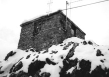 Vue latérale de la station météorologique du mont Sulphur, montrant son volume simple, à un étage, coiffé d’un toit en croupe, 1986.; Environment Canada, Parks Canada, Western Regional Office, 1986 / Environnement Canada, Parcs Canada, Bureau de la région de l'Ouest, 1986.